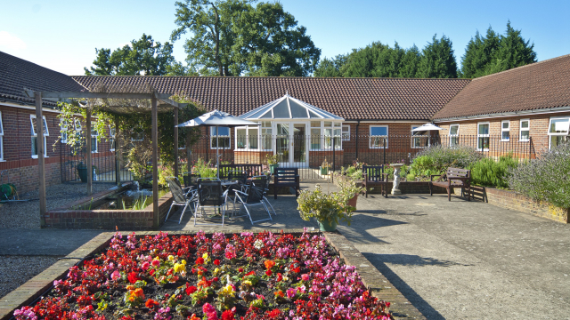 Monread Lodge gardens with outdoor seating and flower beds