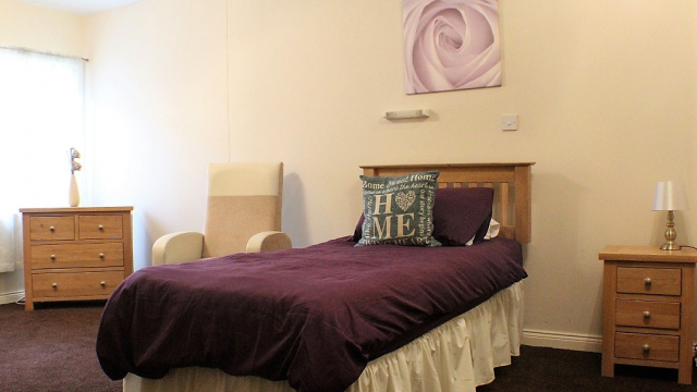 Astor Court bedroom with single bed, chair and storage 