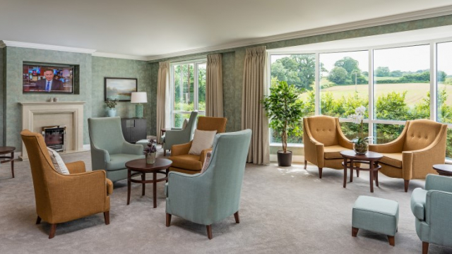 Kings Manor lounge with fireplace and TV
